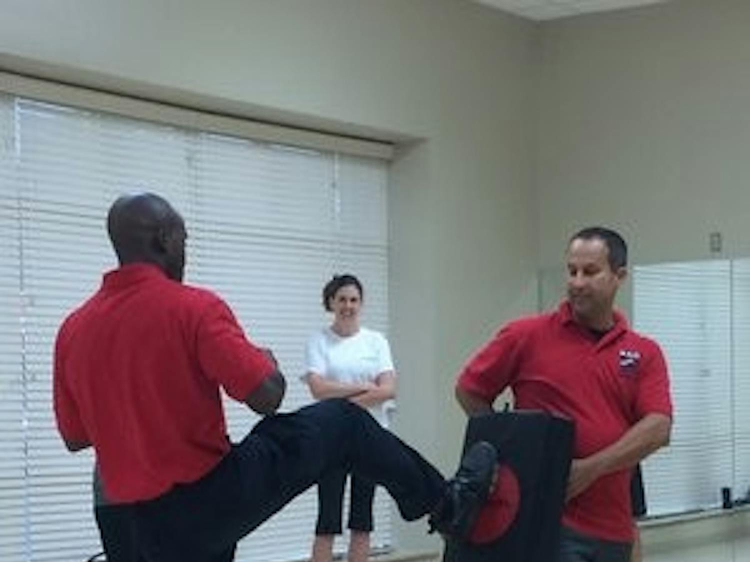 Lt. Jonathan Ley a holds practice pad while officer Antonio Fannin demonstrates technique.