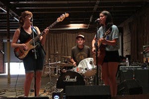 Outskirts (from left: Sierra Farr, Brian McLeod and Lisa Taylor) get set to rock out during the Opelika Shidig Saturday evening. The party was to celebrate local artists, vendors and musical talent at The Railyard, a gallery and exhibition space in downtown Opelika. (Rebecca Croomes / PHOTO EDITOR)