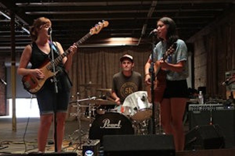 Outskirts (from left: Sierra Farr, Brian McLeod and Lisa Taylor) get set to rock out during the Opelika Shidig Saturday evening. The party was to celebrate local artists, vendors and musical talent at The Railyard, a gallery and exhibition space in downtown Opelika. (Rebecca Croomes / PHOTO EDITOR)