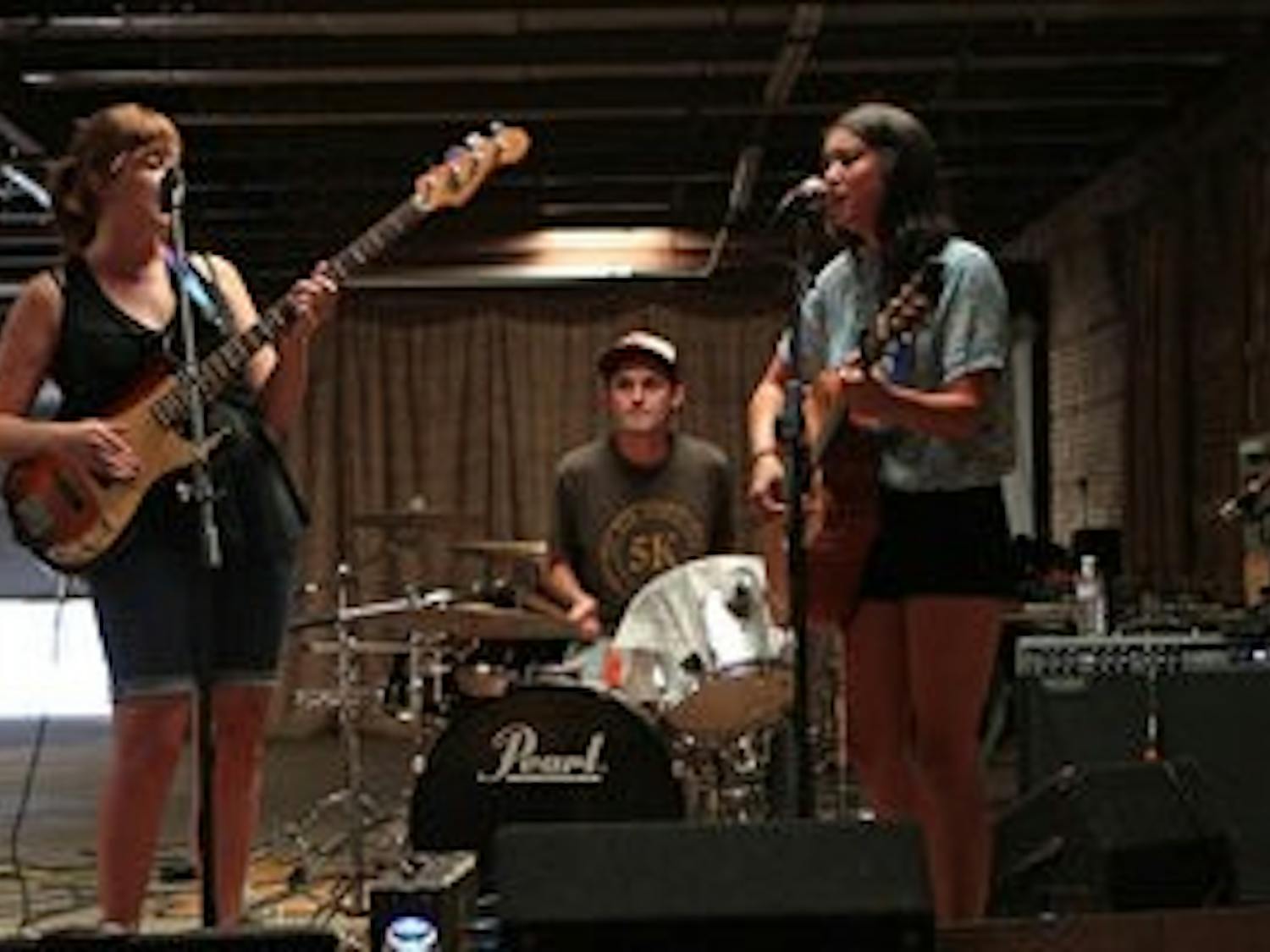 Outskirts (from left: Sierra Farr, Brian McLeod and Lisa Taylor) get set to rock out during the Opelika Shidig Saturday evening. The party was to celebrate local artists, vendors and musical talent at The Railyard, a gallery and exhibition space in downtown Opelika. (Rebecca Croomes / PHOTO EDITOR)