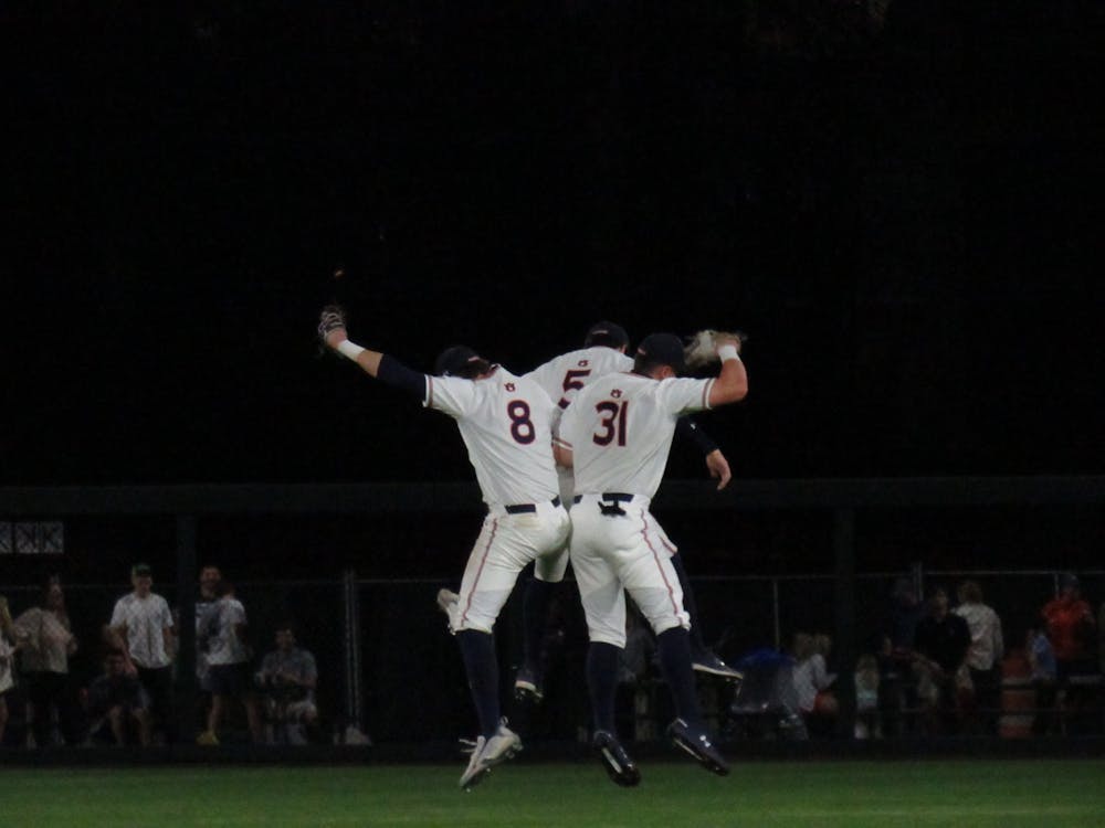 <p>Teammates Bryson Ware (8), Kason Howell (5), and Mike Bello (31) celebrate after a win against Rhode Island on May 4, 2022 at Plainsman Park in Auburn, Ala.</p>