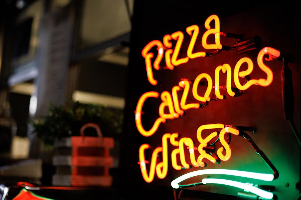 <p>Outside "Prim's Pizza" sits a sign that reads "pizza, calzone, wine" at Food Truck Friday in Opelika, Alabama on Nov. 21, 2025.</p>
