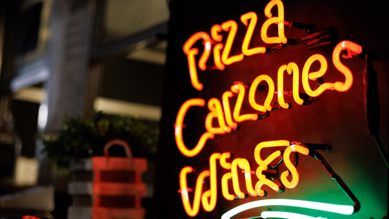 Outside "Prim's Pizza" sits a sign that reads "pizza, calzone, wine" at Food Truck Friday in Opelika, Alabama on Nov. 21, 2025.