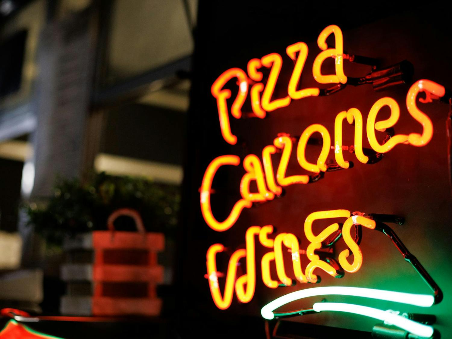 Outside "Prim's Pizza" sits a sign that reads "pizza, calzone, wine" at Food Truck Friday in Opelika, Alabama on Nov. 21, 2025.