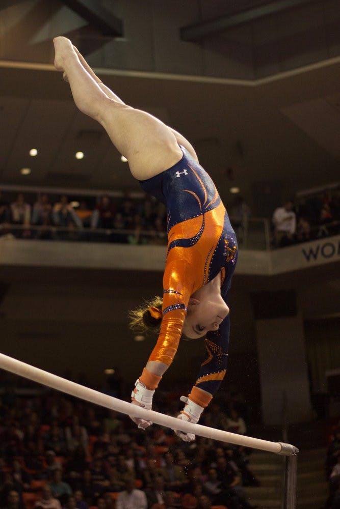 Caitlin Atkinson does a handstand on the uneven bars during the Auburn vs Alabama gymnastics meet. Jenna Burgess / PHOTOGRAPHER