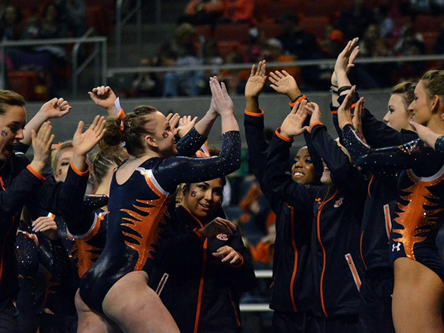 Caitlin Atkinson celebrates with team after successful routine on the beam. Auburn Gymnastics vs Arkansas in Auburn, AL on Jan 23, 2015. Emily Enfinger | PHOTO EDITOR