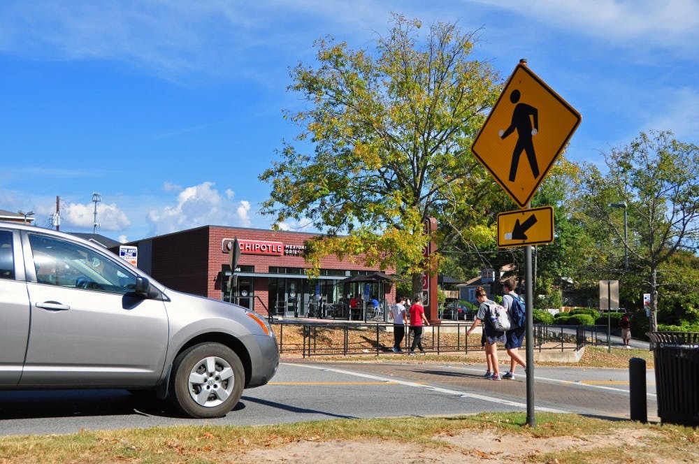 A car stops as students walk across a crosswalk that extends from campus to Chipotle on Thursday, Nov. 3, 2016, in Auburn, Ala.