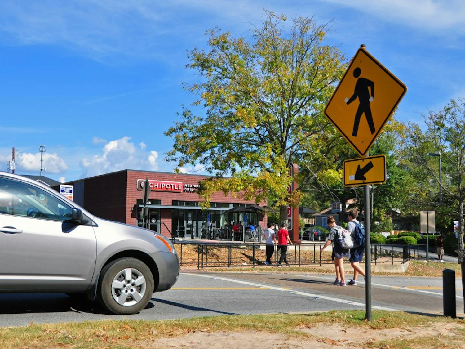 A car stops as students walk across a crosswalk that extends from campus to Chipotle on Thursday, Nov. 3, 2016, in Auburn, Ala.