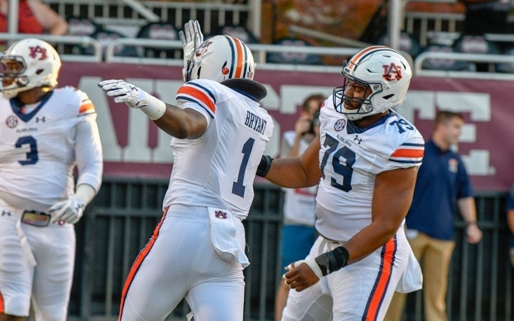 <p>Big Kat Bryant (1) and Andrew Williams (79) go through pregame warmups before Auburn football vs. Mississippi State on Oct. 6, 2018, in Starkville, Miss.</p>