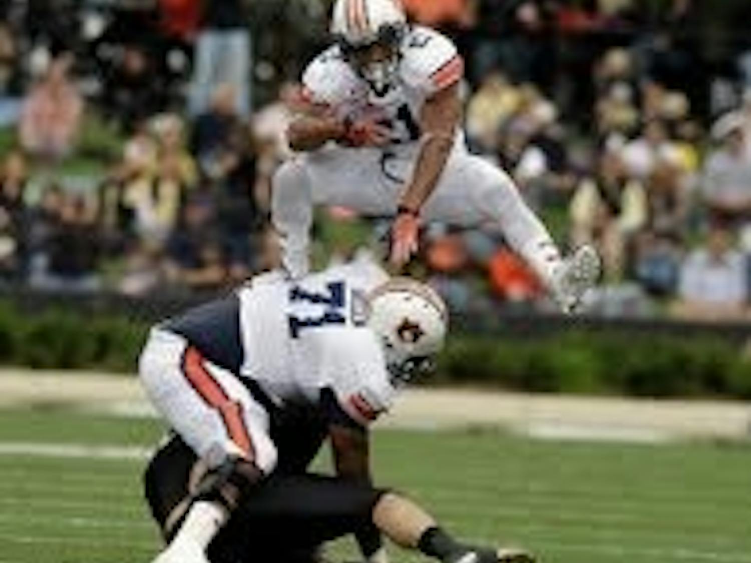 Auburn running back Tre Mason hurdles his way to part of a 16 carry, 85 yard performance. (Todd Van Emst)