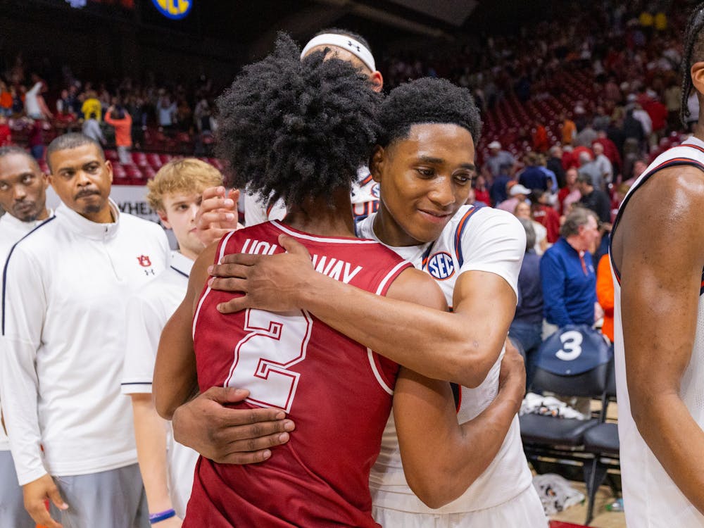Aden Holloway and Tahaad Pettiford embrace after Auburn beat Alabama on Feb. 15, 2024.