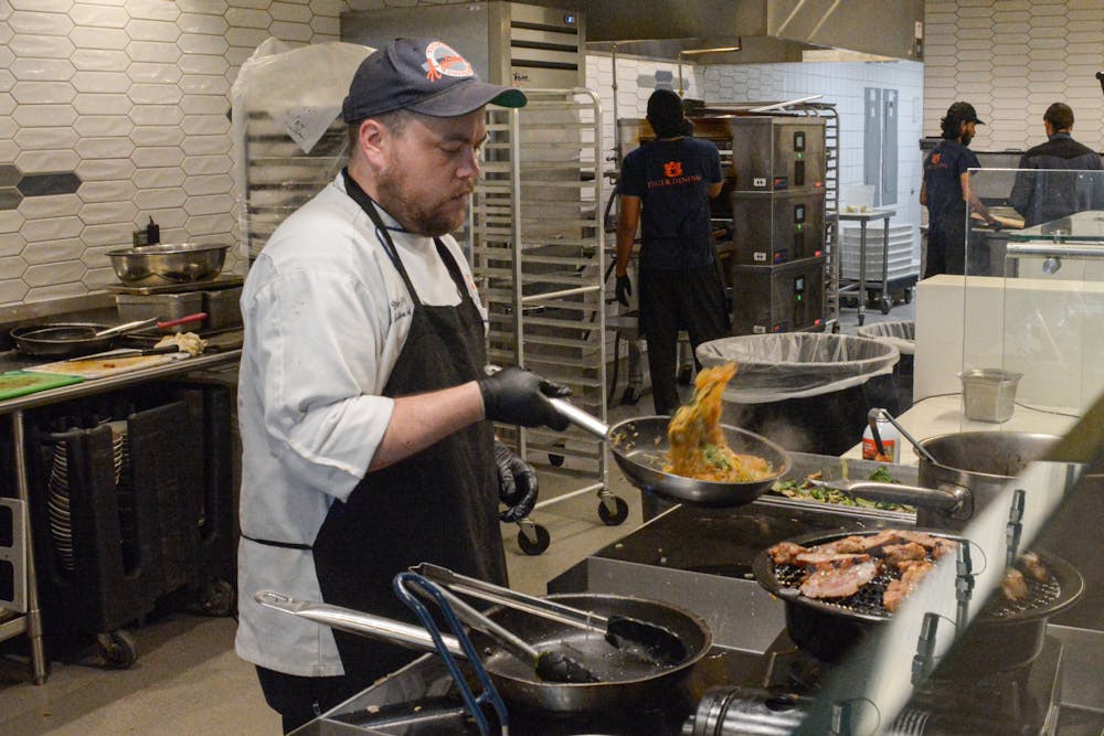 District executive chef Brian Miller preparing the Admin Team's dish "Taste of Asian Cuisine" with char grilled lemongrass pork and Korean glass noodles at the Chef Wars in The Edge at Central Dining on March 25, 2024.