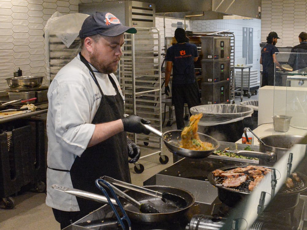 District executive chef Brian Miller preparing the Admin Team's dish "Taste of Asian Cuisine" with char grilled lemongrass pork and Korean glass noodles at the Chef Wars in The Edge at Central Dining on March 25, 2024.