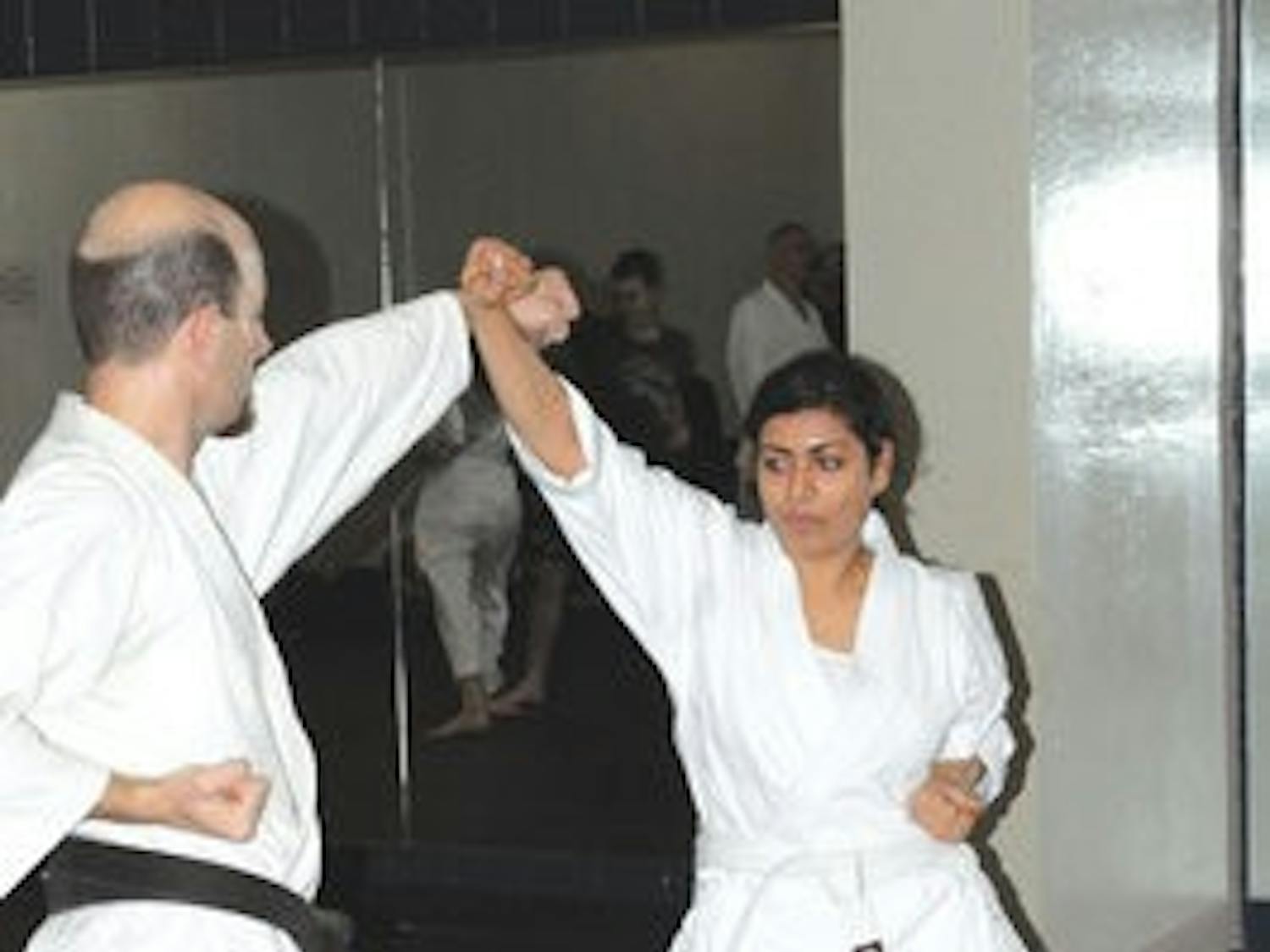 Shannon Price and Dilbur Arsiwalla participate in a partner exercise that combines defensive tactics and offensive movements at practice Thursday. (Christen Harned / ASSISTANT PHOTO EDITOR)