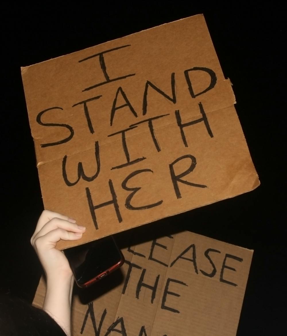 <p>Auburn students raise signs in protest of recent sexual assaults on Sept. 14, 2021, on Toomer's Corner in Auburn, Ala.</p>