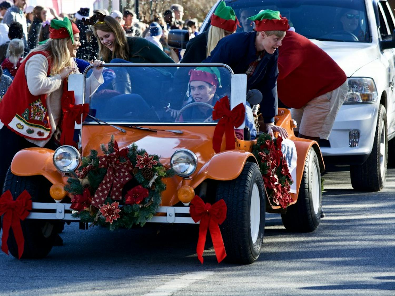 Members of Auburn University SGA jump out of their car to walk during the annual Auburn Christmas Parade, On Sunday, Dec. 10, 2017.