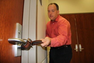 Chance Corbett, associate director of emergency management, demonstrates one way to bar a door closed in an emergency situation. (Courtesy of Chance Corbett)