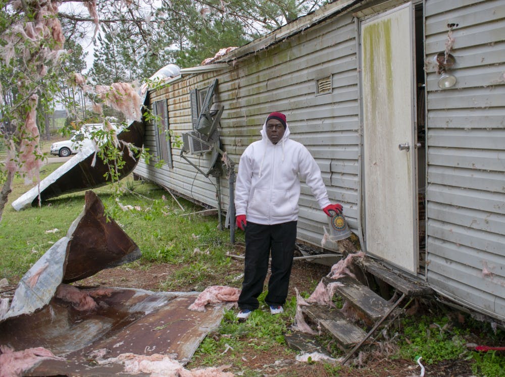 <p>Johnny Washington stands next to the tree stump that held his home in place when a EF-4 tornado passed by on Sunday, March 3, 2019.</p>