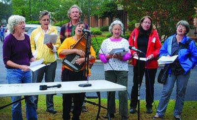 A group of singers leads protestors in "This Land is Your Land" at a protest against the new immigration law. (Maria Iampietro / PHOTO EDITOR)