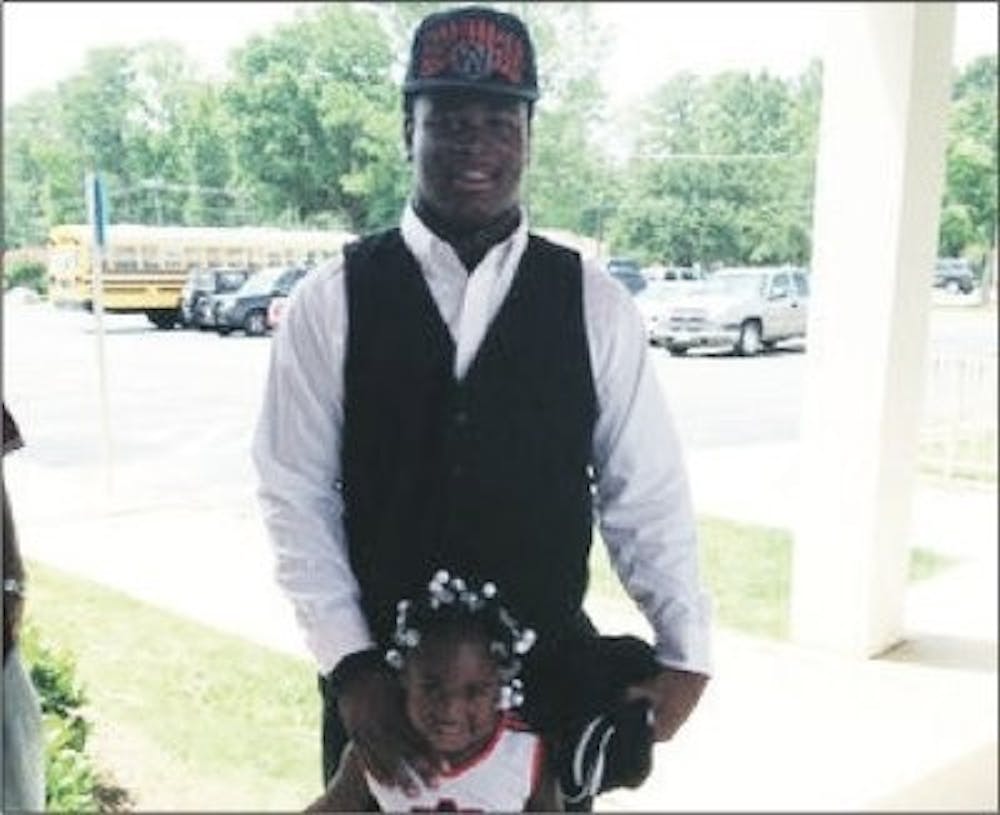Reuben Foster in Auburn garb with his daughter on campus. (Robert Lee / EDITOR-IN-CHIEF)