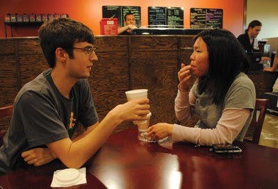 Randall Kaemmerer, senior in art, and Jennifer Thai, junior in graphic design, enjoy coffee and a snack at Magnolia Coffee and Tea Co. The shop offers locally roasted coffee. (Maria Iampietro / Assistant Photo Editor)