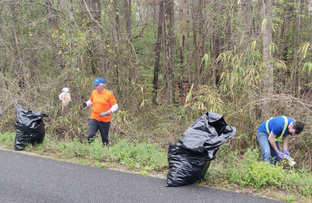 Volunteers pick up trash along the road during the last Operation Roadside Cleanup on March 27.
