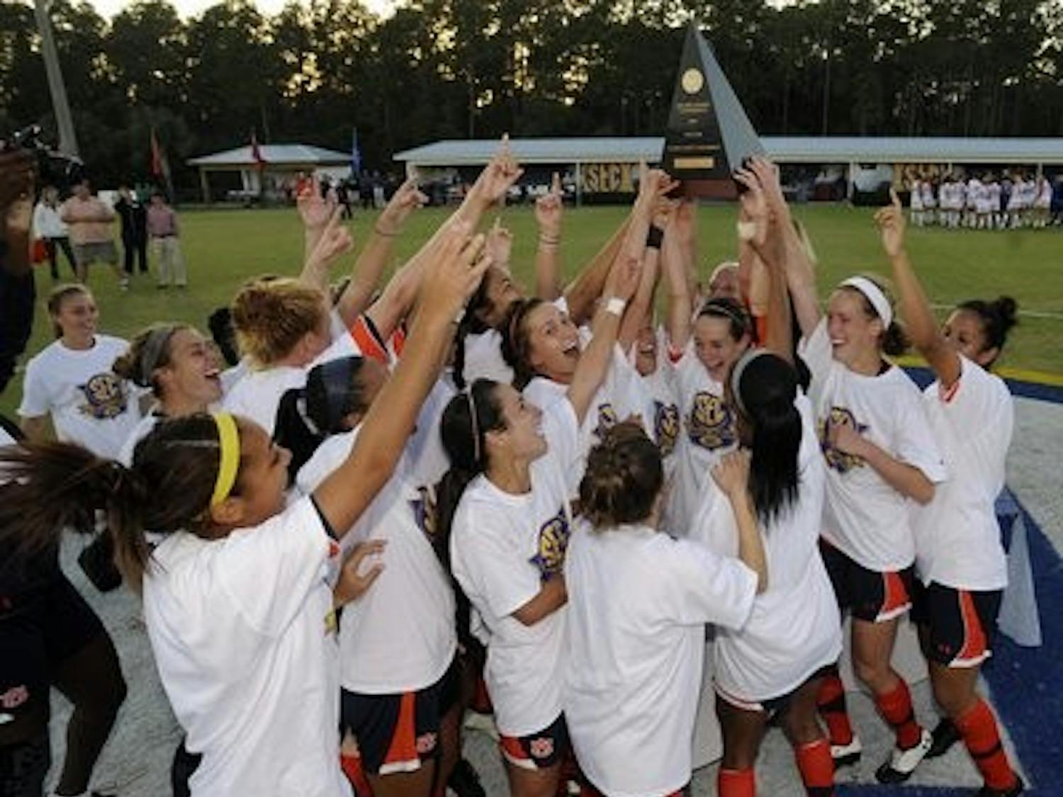 The women of the Auburn soccer team celebrate and hoist the championship trophy after winning their first-ever SEC Tournament after a 3-2 victory over Florida. (Todd Van Emst)