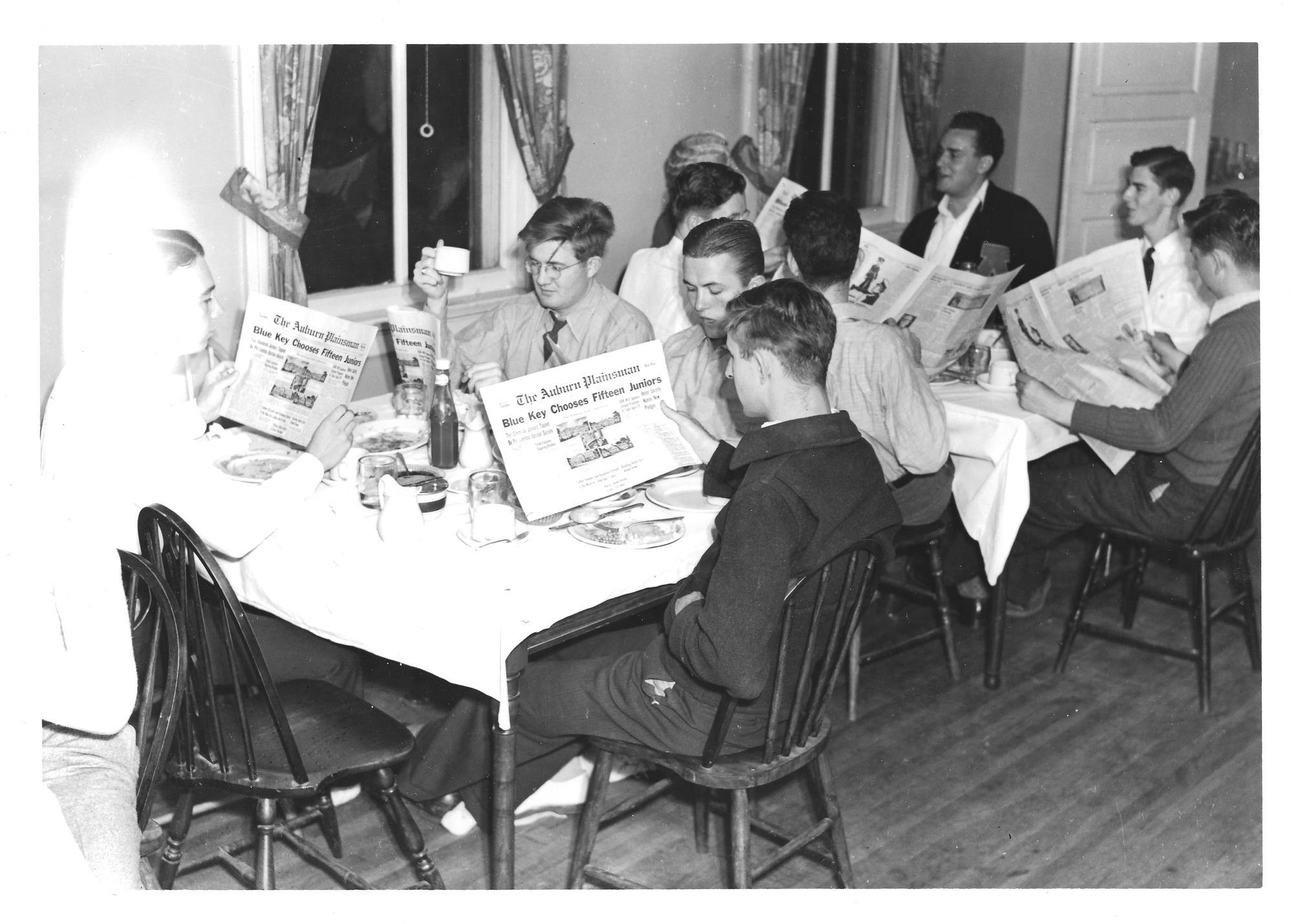 Students gather to read a 1950  to 1970 copy of The Plainsman.