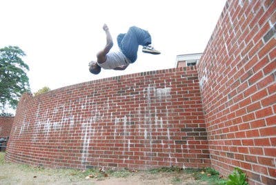 AP member Corsavius Jackson does a backflip after planting one foot on the wall outside the RBD Library parking deck. Auburn Parkour meets Sundays for one of its tri-weekly training sessions on campus. (Derek Lacey / Associate Campus editor)