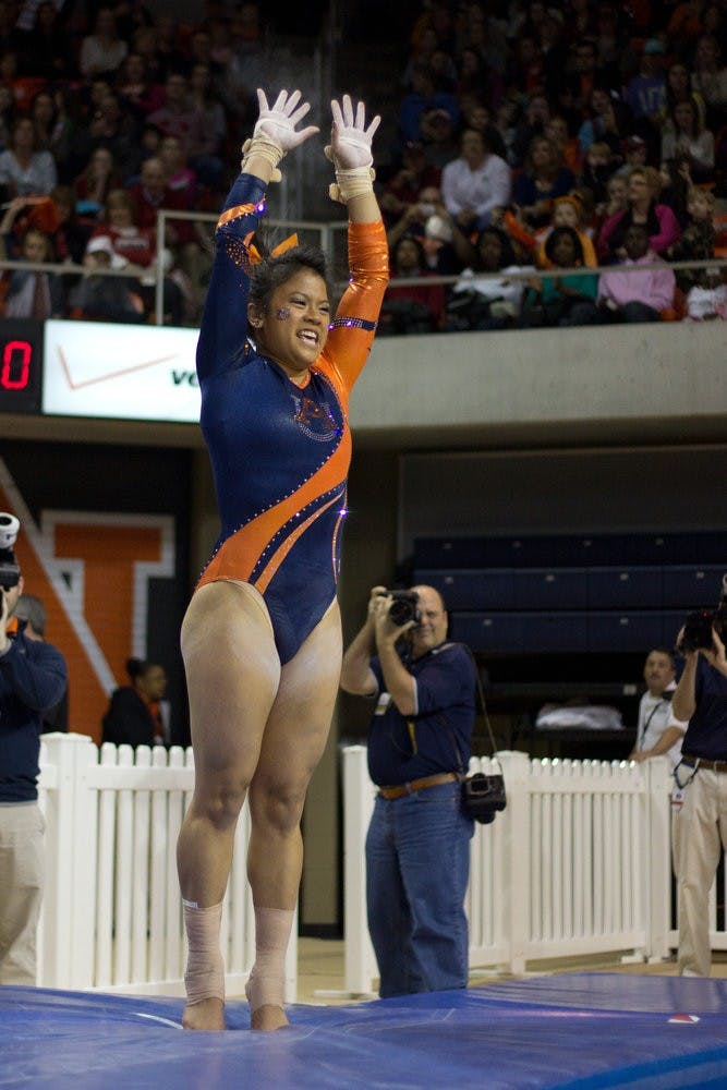 MJ Rott jumps for joy after sticking her landing during the Auburn vs Alabama gymnastics meet. Jenna Burgess / PHOTOGRAPHER