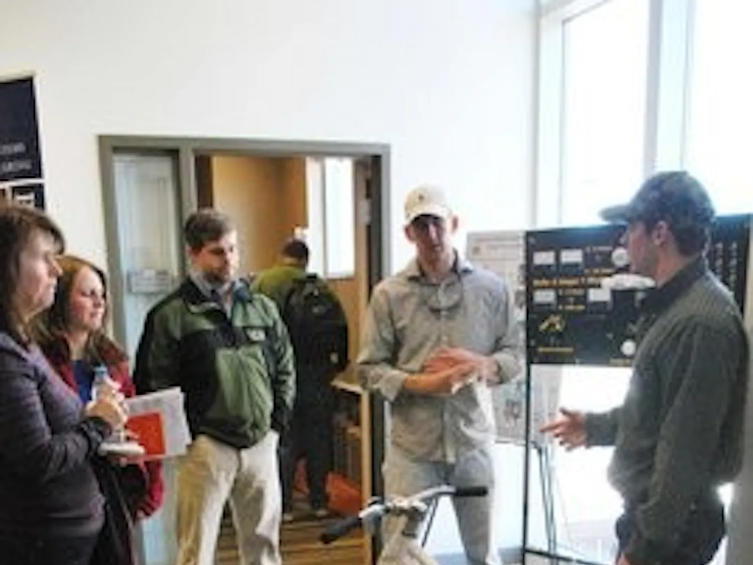John Holt, Jeff Aland and Blake Holden, three Biosystems Engineering majors explain how to create energy from a bicycle. Carolyn Rush / ASSISTANT PHOTO EDITOR