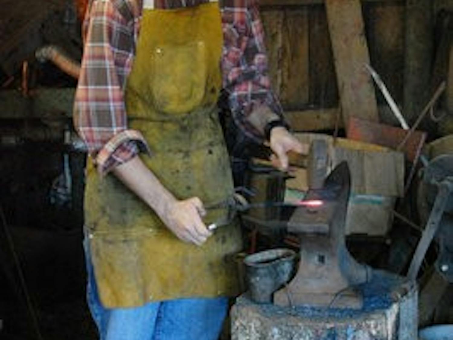 Shachar Newton displays his blacksmithing to onlookers Saturday. (Charlie Timberlake / Assistant Photo Editor)