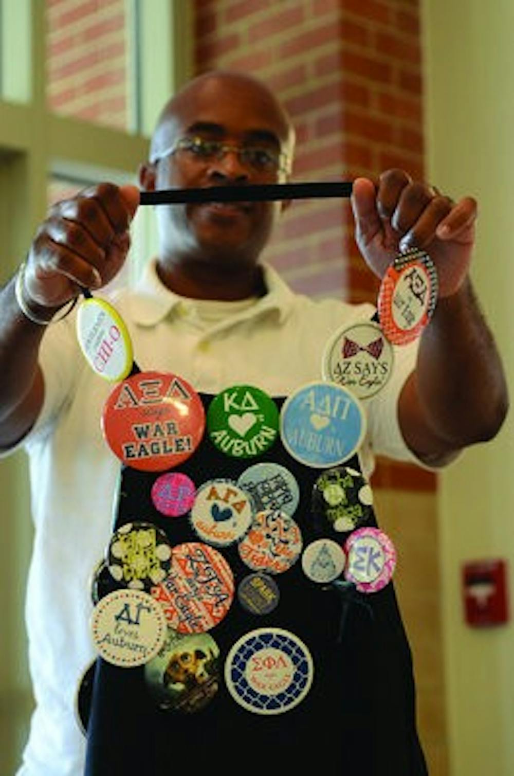 Terrence Bradley displays many buttons he has collected since he started working at Auburn University. (Photo by Raye May | Photo & Design Editor)