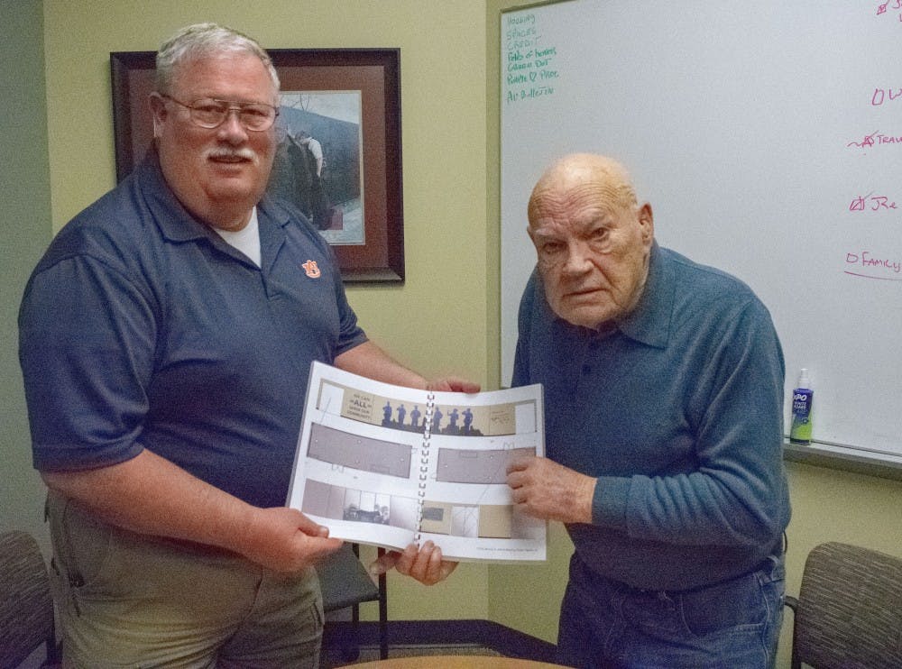 County Commissioner Johnny Lawrence and Command Sergeant Major Bennie G. Adkins hold plans for the new exhibit in the Bennie Adkins Meeting Center. 