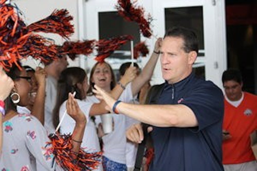 Coach Gene Chizik waved to fans as the team left for Mississippi State on Friday. (Emily Morris / ASSISTANT PHOTO EDITOR)
