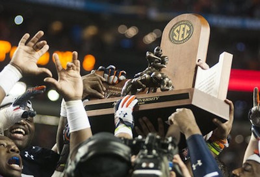 Auburn holding the SEC Championship trophy up after the win Saturday, Dec 7. (Zachary Bland / PHOTOGRAPHER)