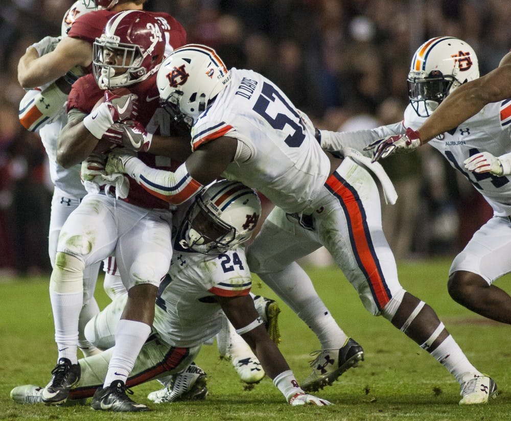 Deshaun Davis (57) tackles Alabama's Damien Harris (34) in the second half. Auburn vs Alabama on Saturday, Nov. 26 in Tuscaloosa, AL.