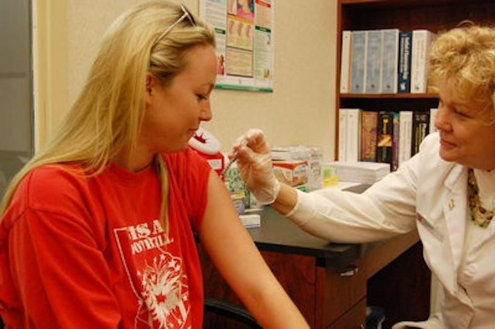 Kristbjorg Johnson (left), senior in public relations, receives a flu shot from Lila Wright (right) at Walgreens Sunday. (Charlie Timberlake / ASSISTANT PHOTO EDITOR)