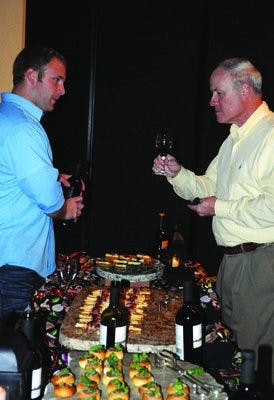 Stacey Chappel explains the wine and food selection to Chris Zodrow at the Wine and Food Festival at the Event Center in downtown Opelika. (Christen Harned / ASSISTANT PHOTO EDITOR )