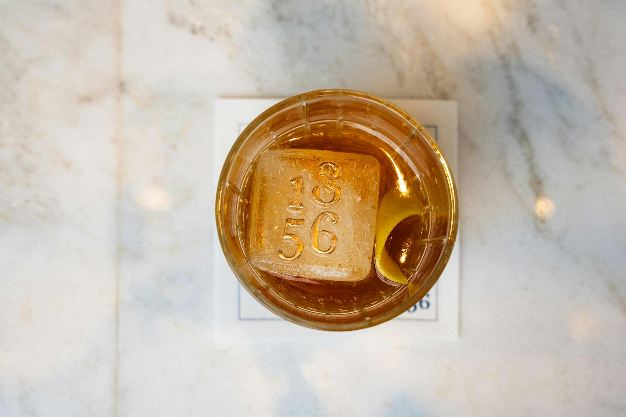 A drink from 1856 – Culinary Residence with an ice cube that has 1856 stamped on it. Contributed by 1856 – Culinary Residence.