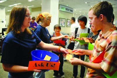 Students receive maps and information about the library as they enter for the annual Ralph Brown Draughon tailgate. (Maria Iampietro / PHOTO EDITOR)