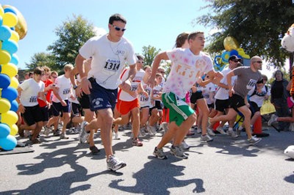 Marathon participants take off at the beginning of the 5K race to raise awareness and funds for Autism Speaks during Alpha Xi Delta's AmaXIng Challenge Sunday. (Charlie Timberlake / ASSISTANT PHOTO EDITOR)