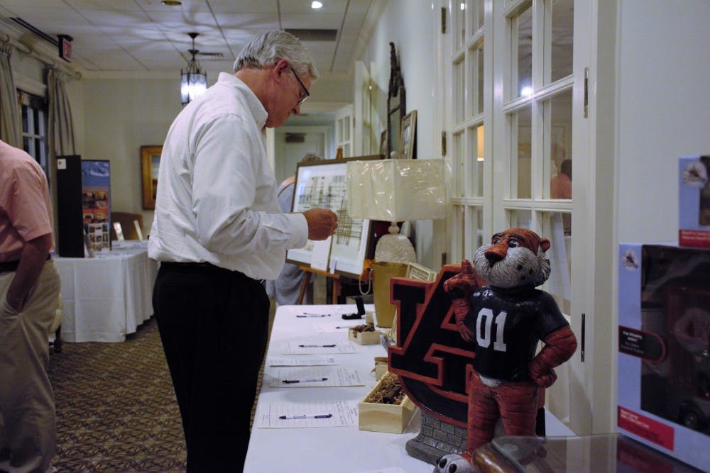 Community members browse the silent auction at Auburn Opelika Habitat for Humanity's annual Habitat around the Heart fundraiser Thursday, July&nbsp;26, 2018 in Opelika, Ala.&nbsp;