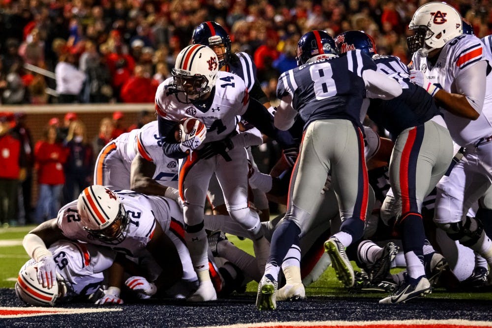 Nick Marshall emerges from the pile to score a touchdown for the Tigers. (Kenny Moss | Photographer)