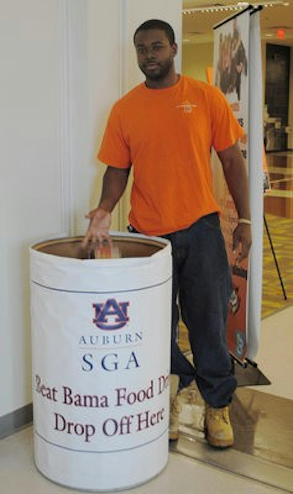 Jonathan Howard, senior in electrical engineering, drops a can into the Beat Bama bin in the fight against local hunger.  (Elaine Busby / Assistant Photo Editor)