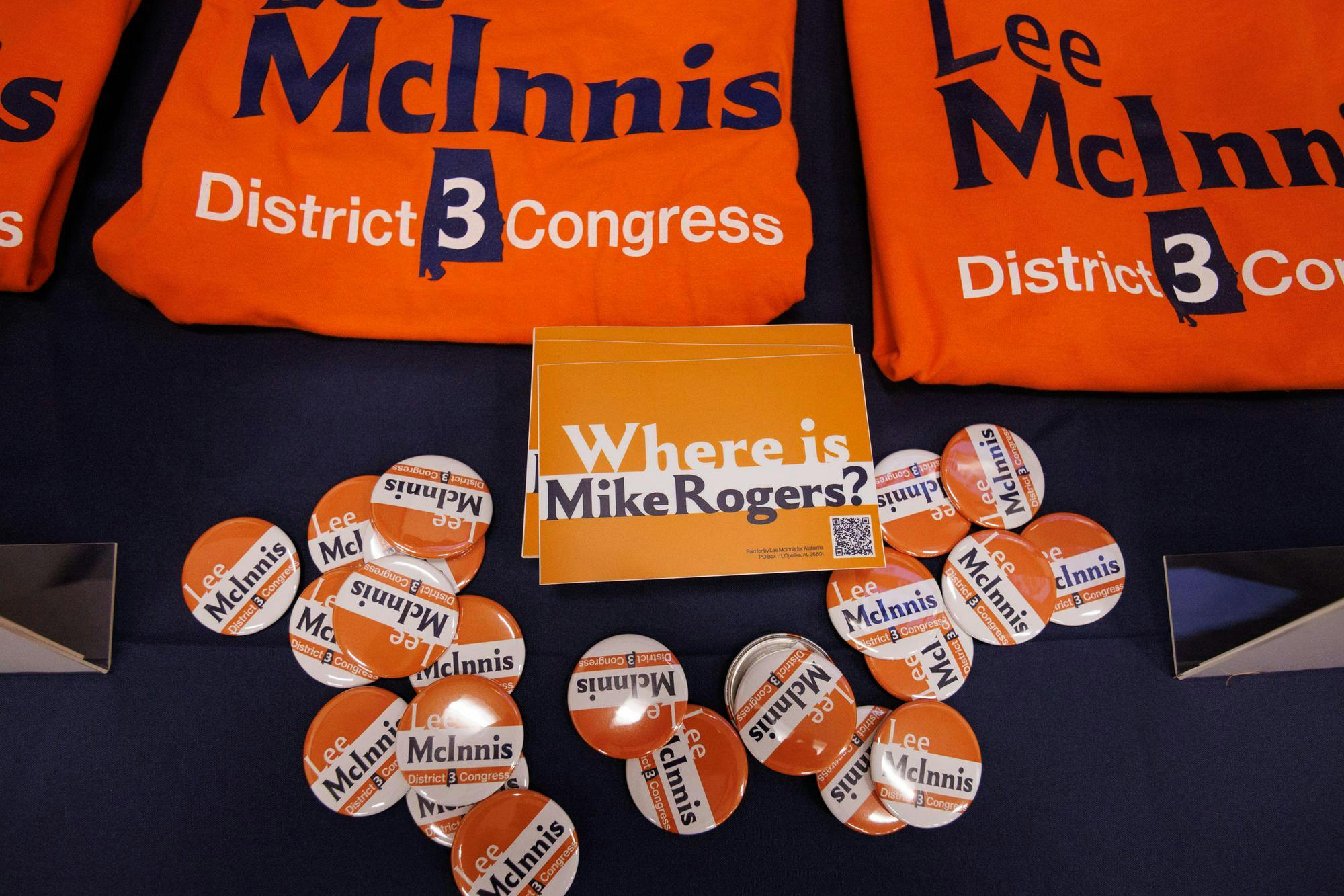 Congressional candidate Lee McInnis has a table set up with merch in the form of T-shirts, buttons and bumper stickers that are given out in response to donations on Nov. 19, 2025.