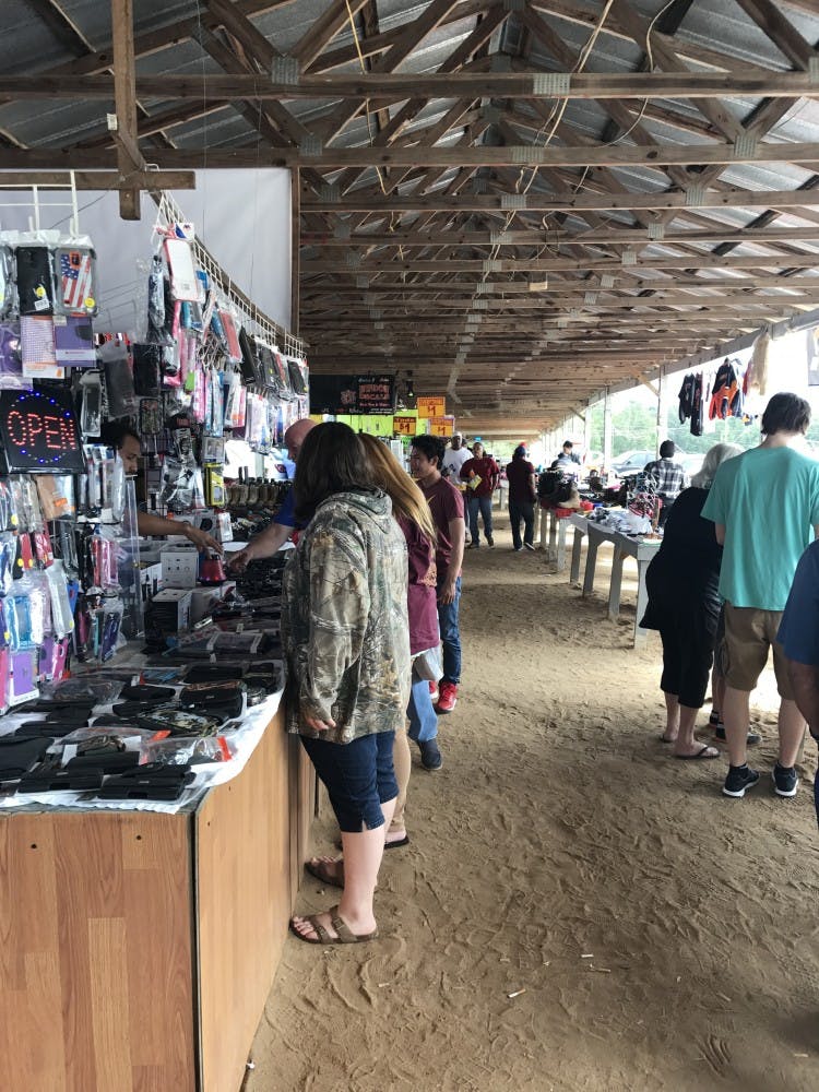 Shoppers browse tables at the Lee County Flea Market in Lee County, Ala.