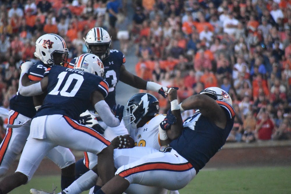 <p>Daniel Thomas (24), Owen Pappoe (10), K.J. Britt (33) and an additional Auburn player tackle a Kent State player for the ball at the Auburn v. Kent State game on Saturday, September 14, 2019 in Auburn, AL.</p>