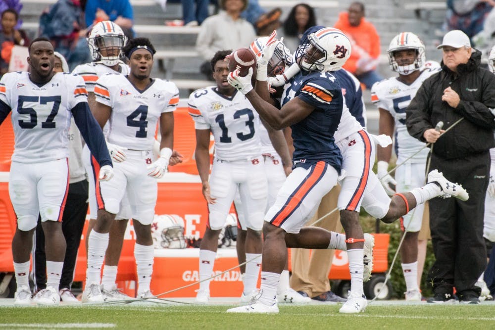 <p>Marquis McClain (17) hauls in a catch with a defender over his shoulder&nbsp;during Auburn's A-Day game on Saturday, April 7, 2018, in Auburn, Ala.</p>