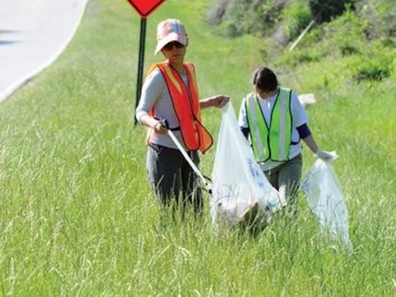 Bochaor Hu, graduate student in fisheries, and Savannah Warren, senior in fisheries, help pick up trash along the road Saturday. (Christen Harned / ASSISTANT PHOTO EDITOR)